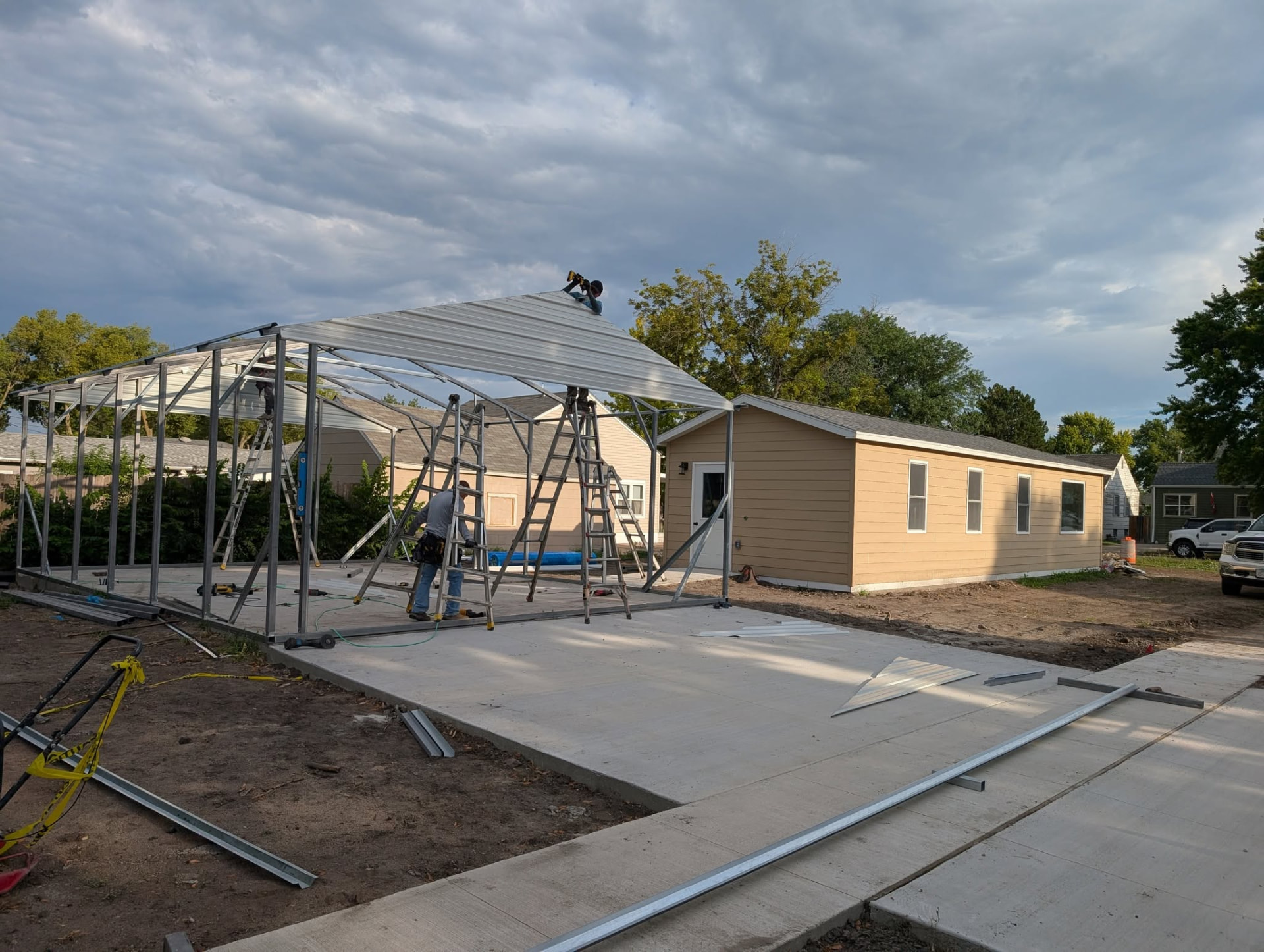 Steel garage frame going up next to the finished home